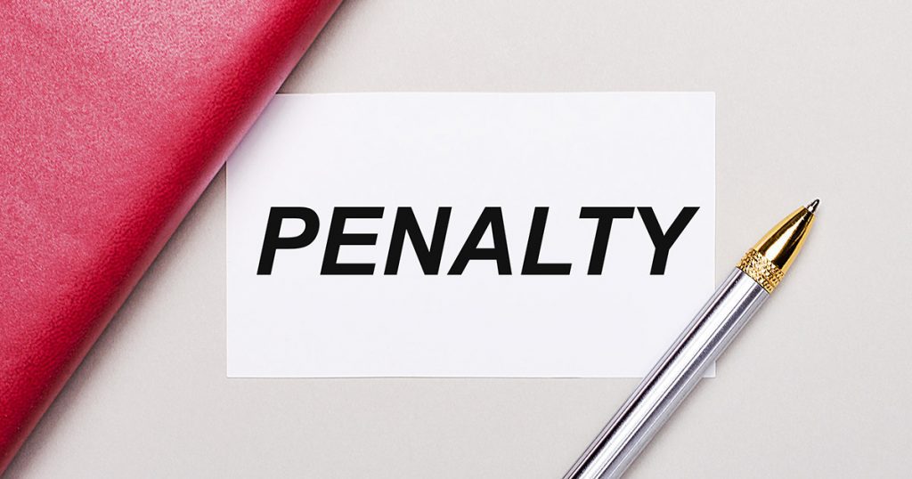Pequeno papel com a palavra “penalty” escrita e uma caneta em cima.