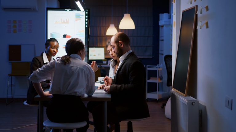Preparação para Auditoria Externa: executivos e executivas reunidos em uma mesa, em ambiente de trabalho.